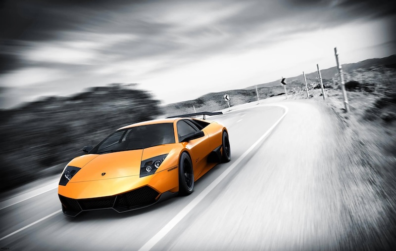 Carta Da Parati Supercar Lamborghini Arancione su Strada - Fotomurale